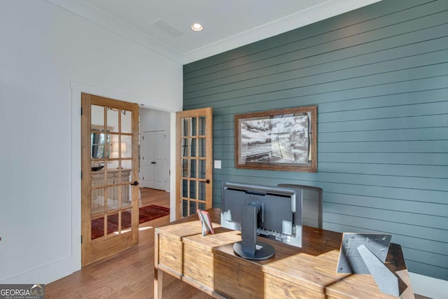 interior space featuring ornamental molding, wooden walls, and hardwood / wood-style flooring