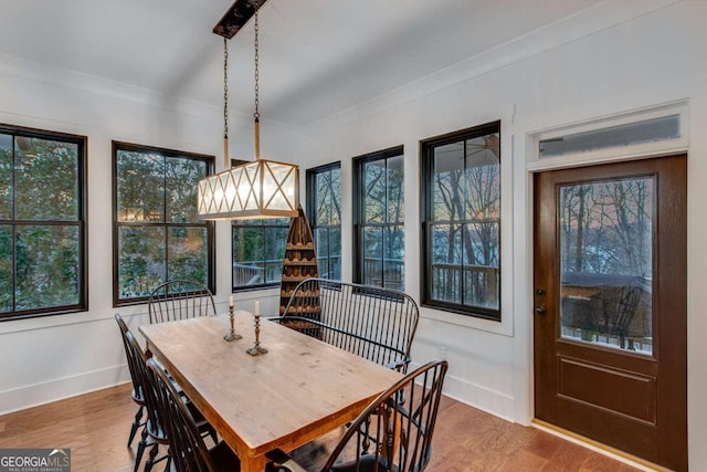 dining room featuring light wood-type flooring and crown molding