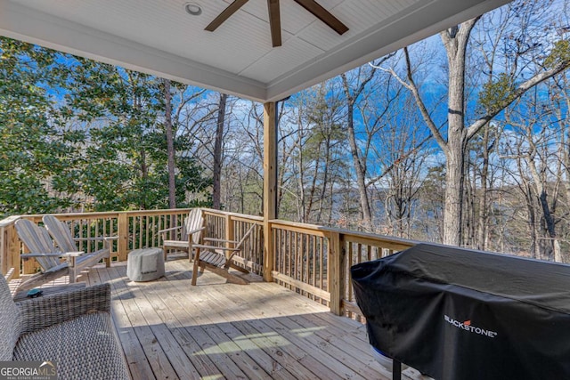 wooden terrace featuring ceiling fan and a grill