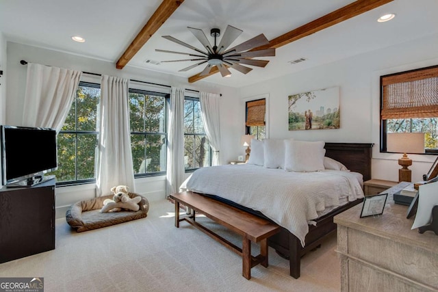 carpeted bedroom with multiple windows, ceiling fan, and beam ceiling