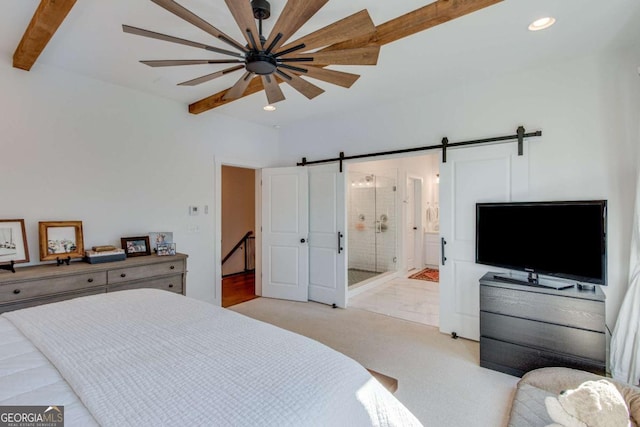 bedroom featuring ensuite bath, light carpet, a barn door, ceiling fan, and beam ceiling