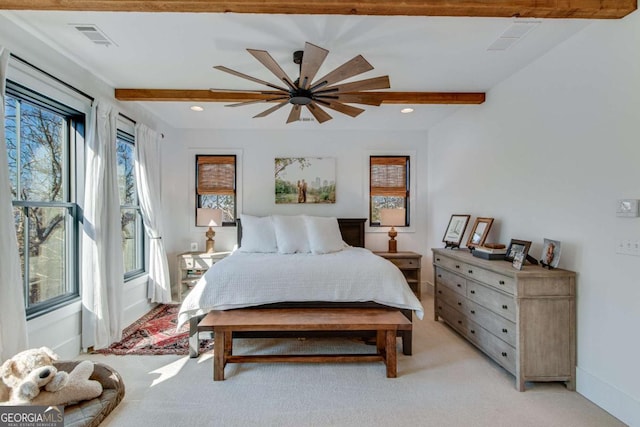 carpeted bedroom with ceiling fan and beamed ceiling