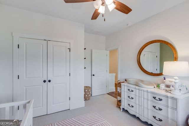 carpeted bedroom with ceiling fan and a closet