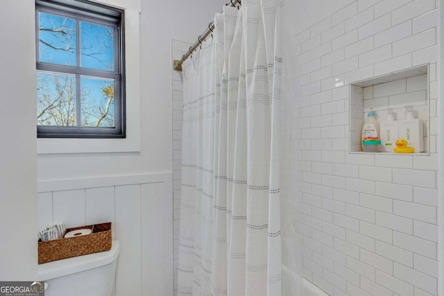 bathroom featuring shower / bath combo with shower curtain and toilet