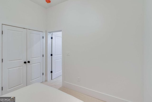 bedroom featuring light colored carpet and a closet