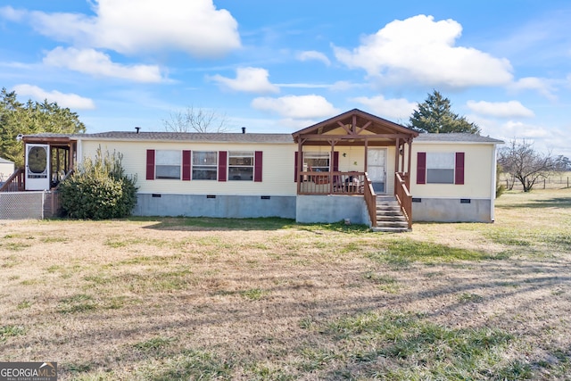 manufactured / mobile home with covered porch and a front yard