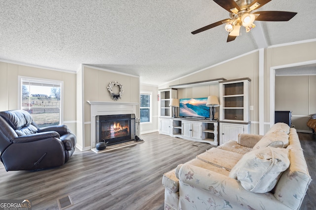 living room featuring a textured ceiling, crown molding, lofted ceiling, and hardwood / wood-style flooring