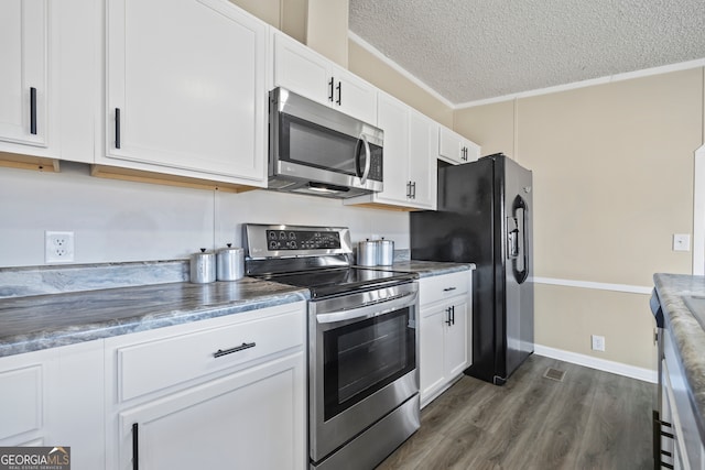 kitchen featuring stainless steel appliances, ornamental molding, dark hardwood / wood-style floors, a textured ceiling, and white cabinetry