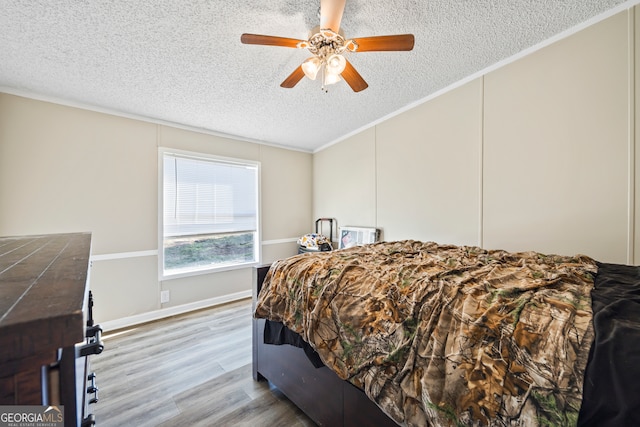 bedroom featuring ceiling fan, crown molding, a textured ceiling, and wood-type flooring