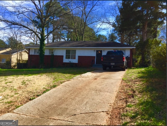 ranch-style house with a garage and a front lawn