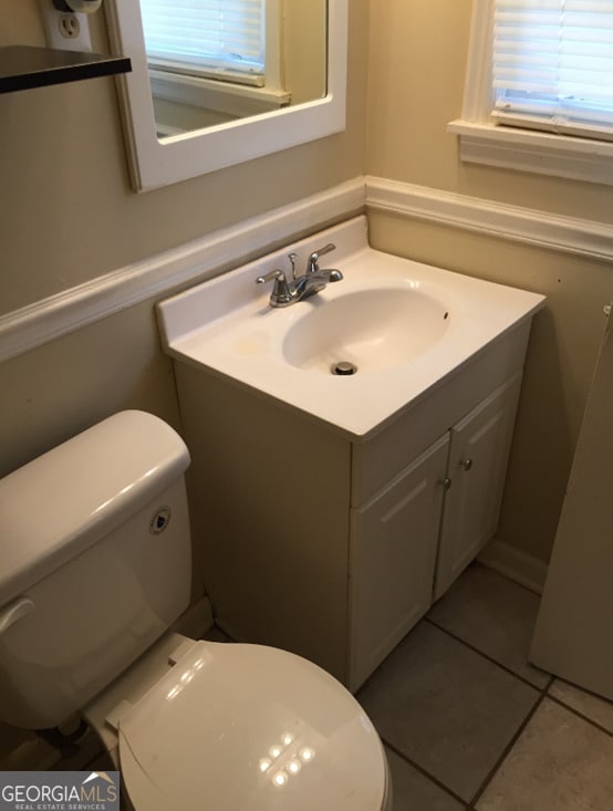 bathroom with tile patterned flooring, vanity, and toilet