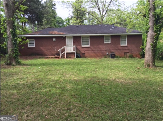 rear view of property featuring a yard