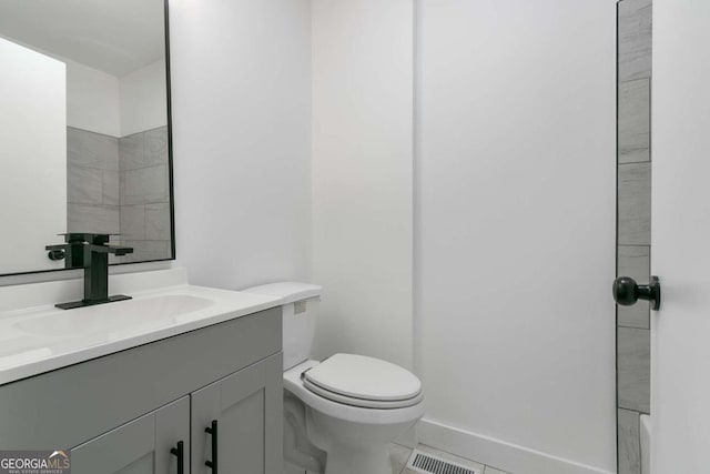 bathroom with toilet, tile patterned floors, and vanity