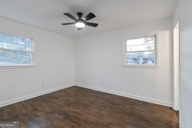 empty room featuring ceiling fan and dark hardwood / wood-style floors