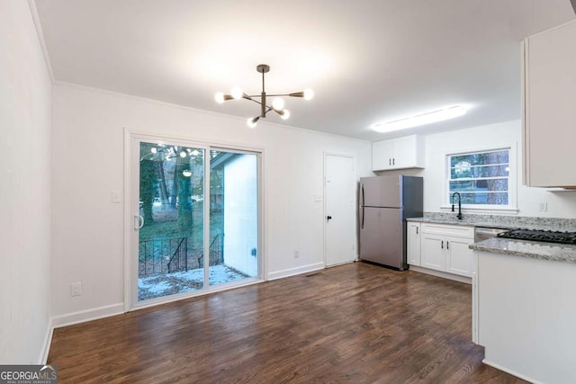 kitchen featuring light stone countertops, a notable chandelier, dark hardwood / wood-style flooring, white cabinetry, and appliances with stainless steel finishes