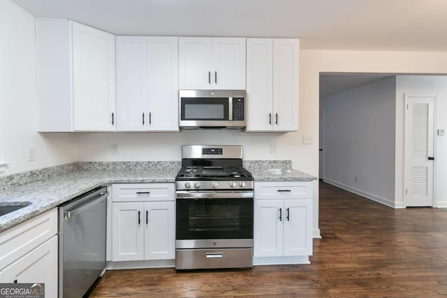 kitchen featuring light stone counters, stainless steel appliances, and white cabinetry