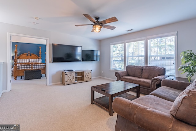 living room featuring light carpet and ceiling fan