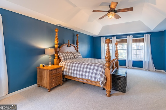 carpeted bedroom with ceiling fan and a tray ceiling