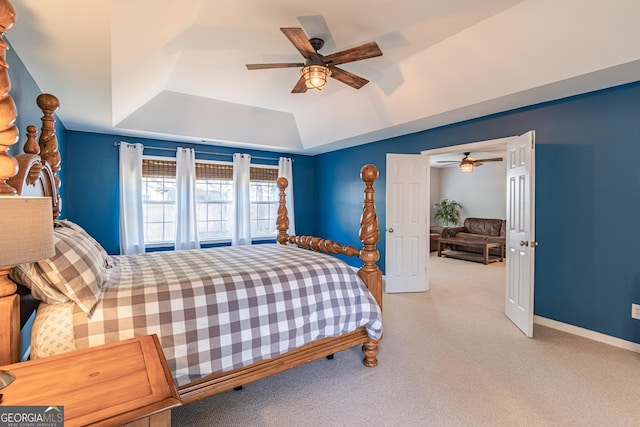 carpeted bedroom with ceiling fan and a tray ceiling