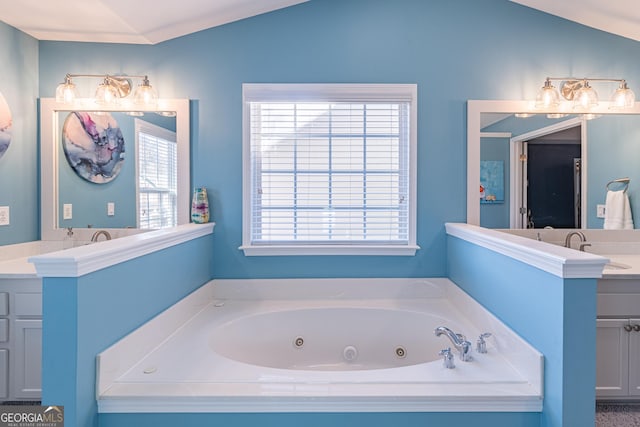 bathroom with a bathtub, vanity, and vaulted ceiling