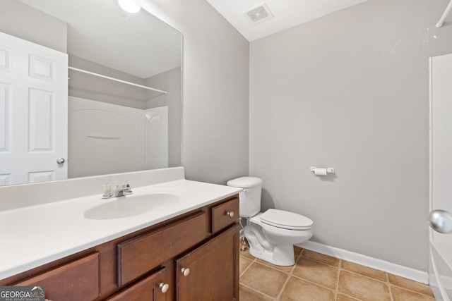 bathroom with toilet, tile patterned flooring, walk in shower, and vanity