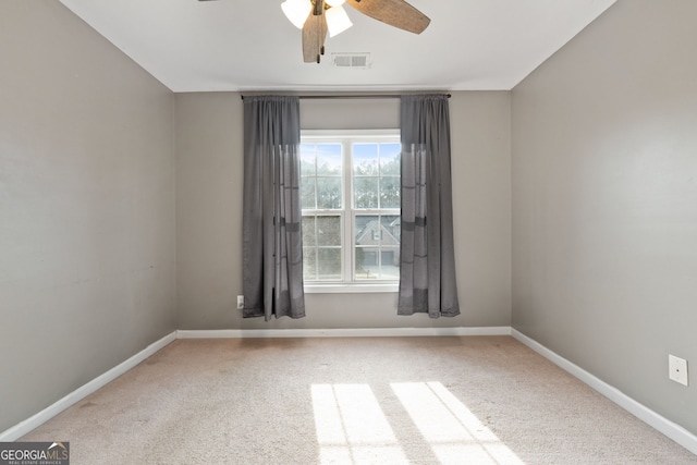 carpeted spare room with ceiling fan