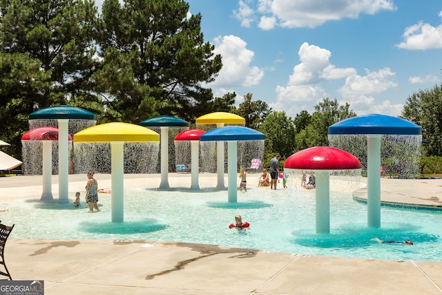 view of jungle gym with pool water feature and a community pool