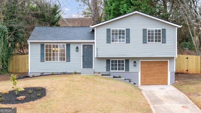 tri-level home featuring a garage and a front lawn