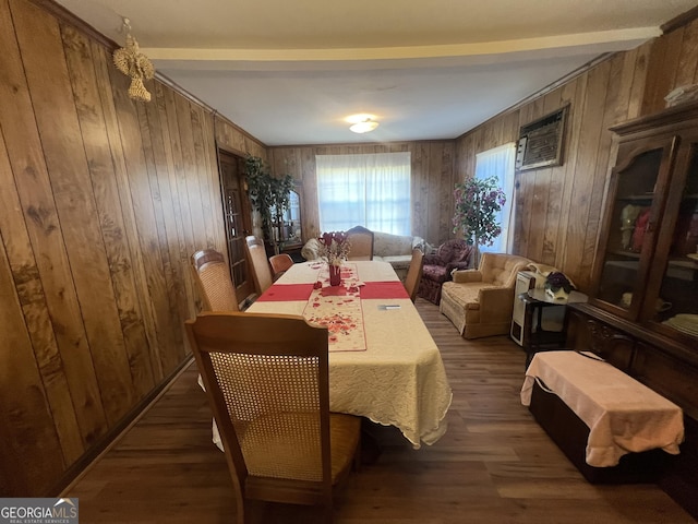 dining room featuring dark wood-type flooring, wood walls, and beamed ceiling