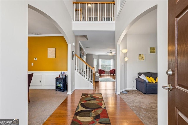 foyer entrance with ceiling fan, wood-type flooring, and ornamental molding