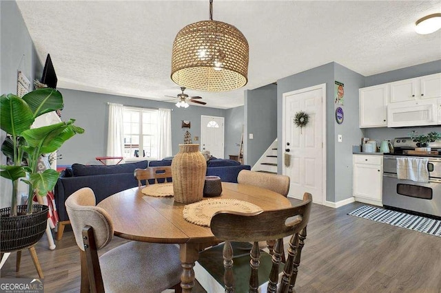 dining space with dark hardwood / wood-style flooring, a textured ceiling, and ceiling fan