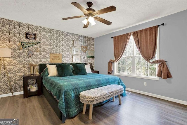 bedroom featuring ceiling fan, dark hardwood / wood-style flooring, and a textured ceiling