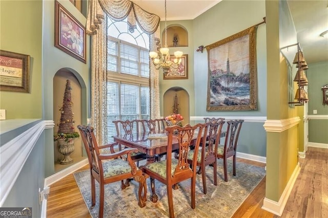 dining space with ornamental molding, light hardwood / wood-style flooring, and a chandelier