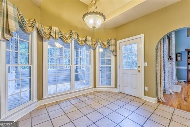 entryway with a wealth of natural light and light tile patterned floors