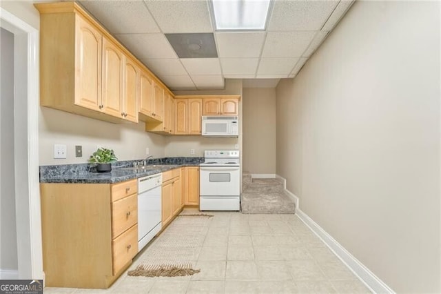 kitchen with light brown cabinets, white appliances, and a drop ceiling