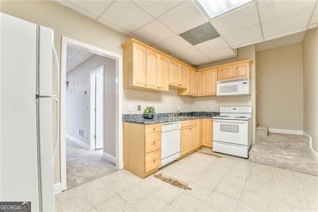 kitchen featuring white appliances, light brown cabinetry, and light colored carpet