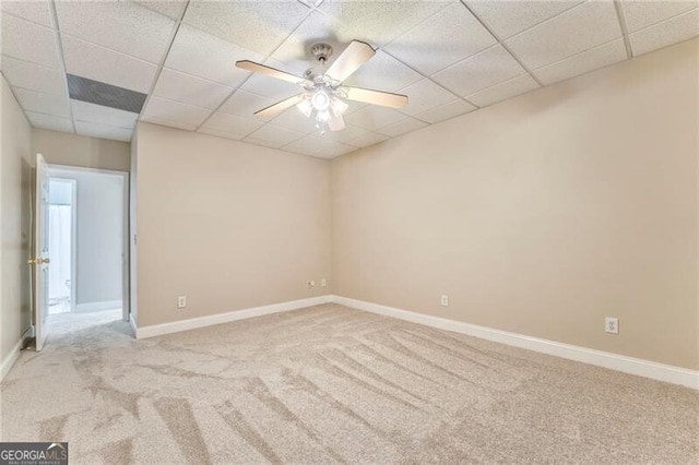 carpeted empty room with a drop ceiling and ceiling fan