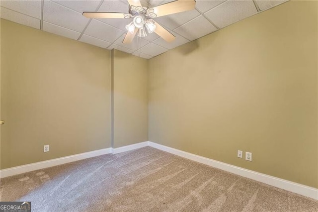 carpeted empty room featuring a drop ceiling and ceiling fan