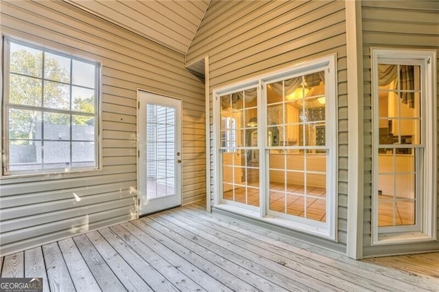 unfurnished sunroom featuring vaulted ceiling