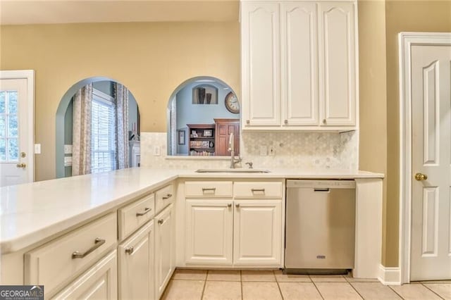 kitchen with sink, dishwasher, light tile patterned floors, tasteful backsplash, and kitchen peninsula