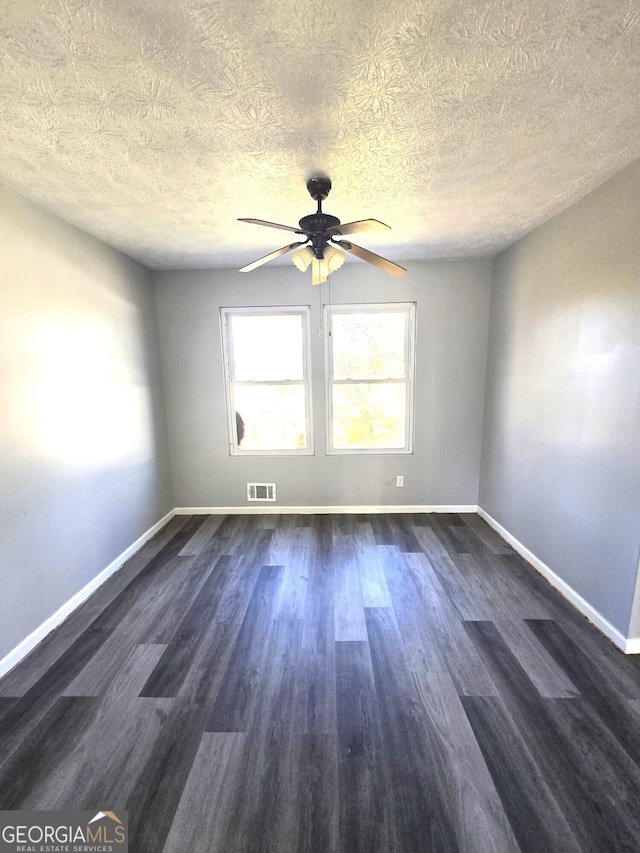 spare room with dark wood-type flooring, a textured ceiling, and ceiling fan