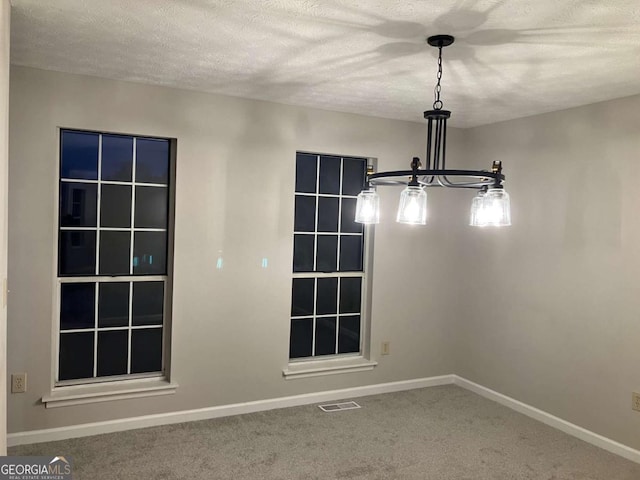 carpeted spare room featuring a textured ceiling