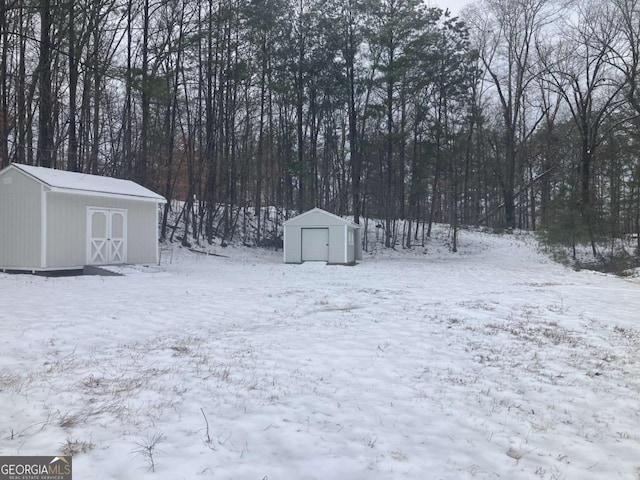 yard layered in snow featuring a storage shed