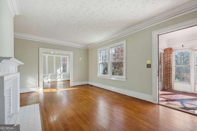 unfurnished living room with ornamental molding, a fireplace, baseboards, and hardwood / wood-style flooring