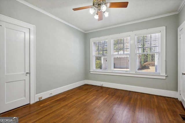 empty room with ceiling fan, ornamental molding, and dark hardwood / wood-style floors