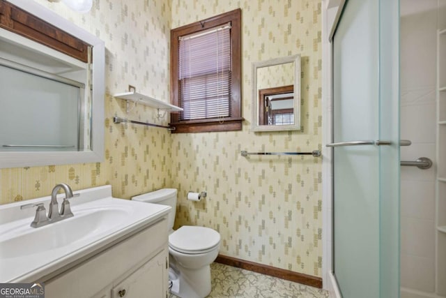 bathroom featuring vanity, a shower with shower door, and toilet