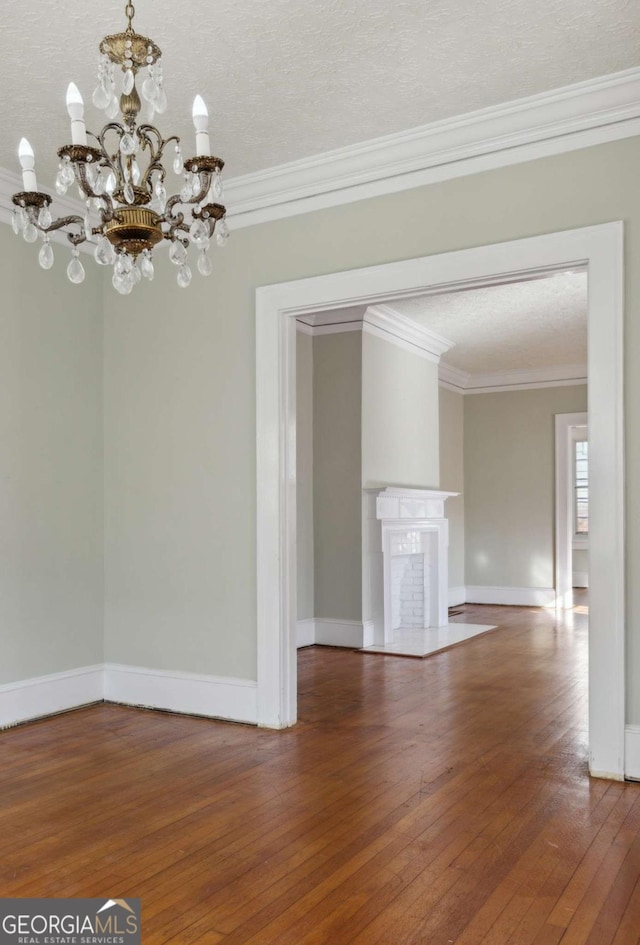 interior space with a fireplace, baseboards, wood-type flooring, and ornamental molding