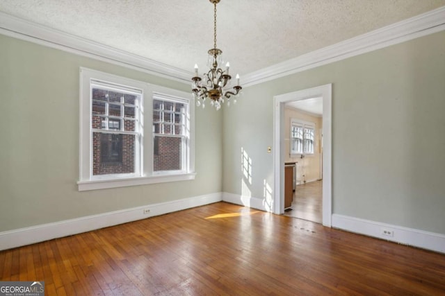 unfurnished room with hardwood / wood-style floors, crown molding, baseboards, and a textured ceiling