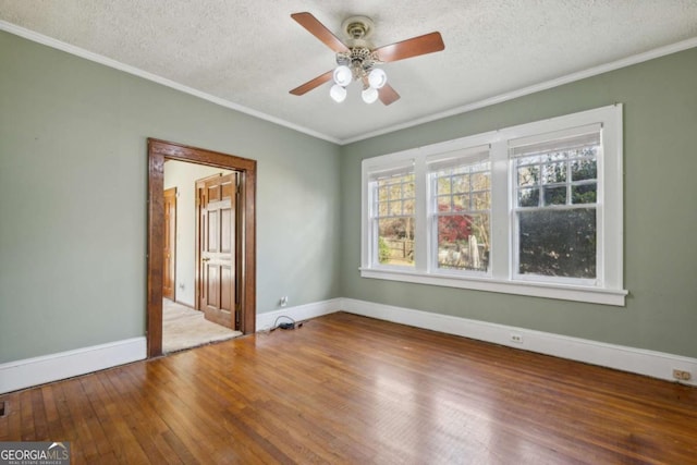 spare room with a textured ceiling, crown molding, and wood-type flooring