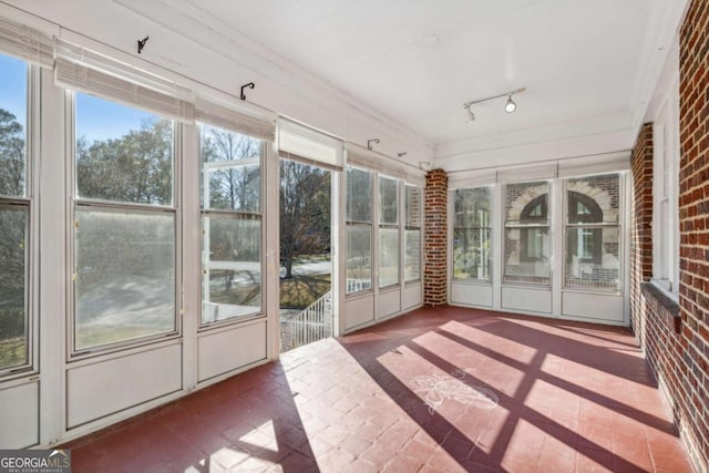 unfurnished sunroom with track lighting and plenty of natural light